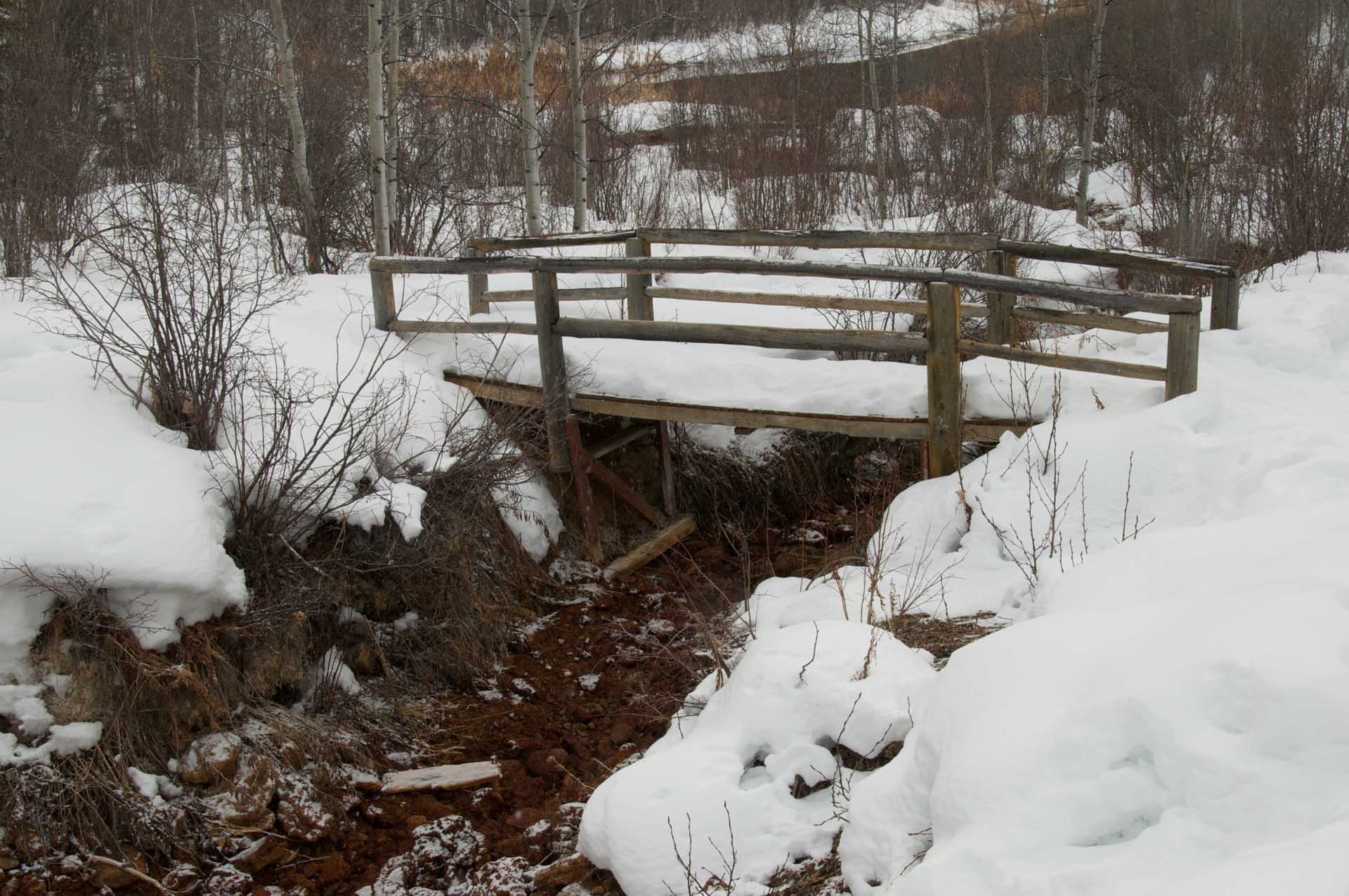 wooden bridge covered in snow